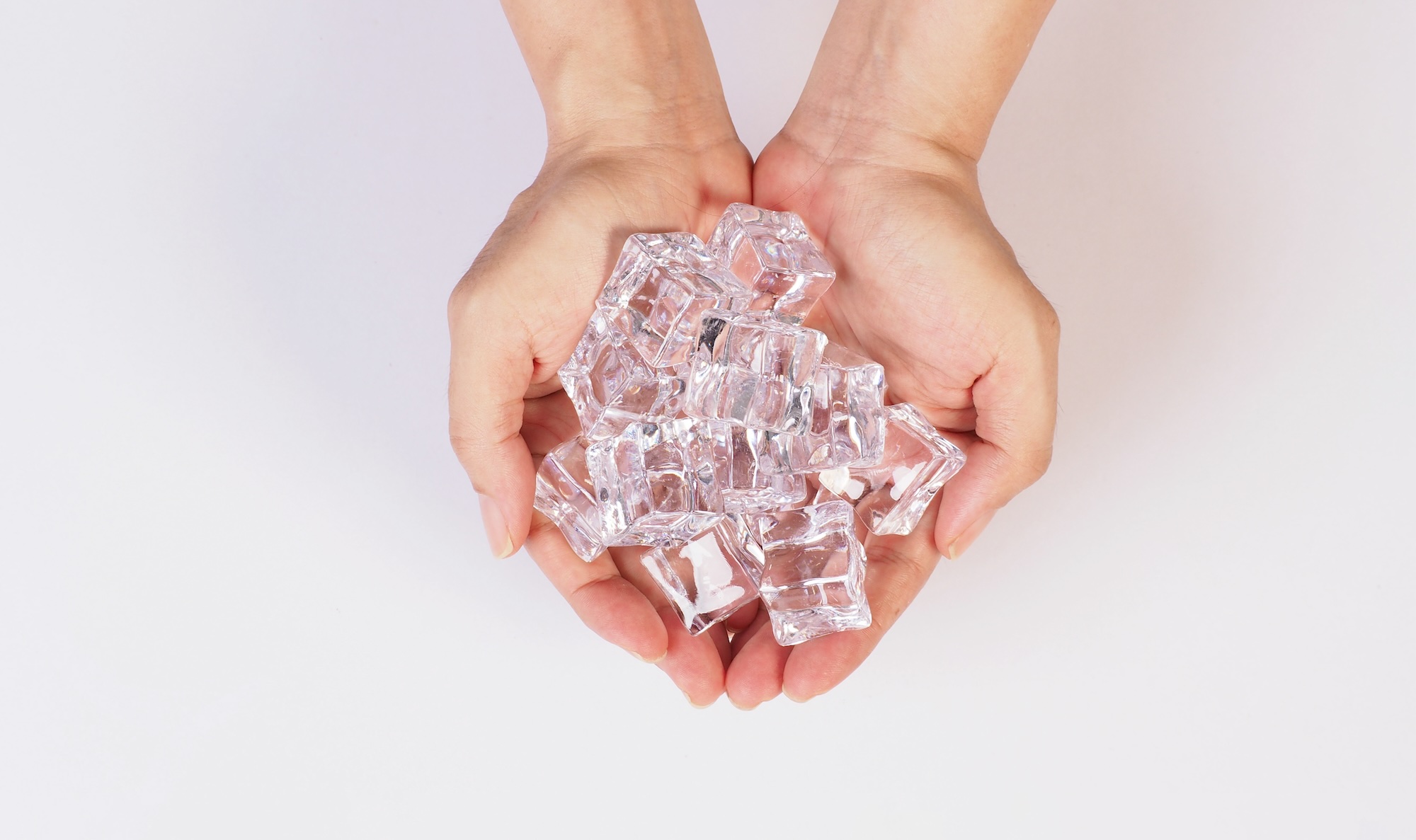 hands is holdine ice cubes isolated on white background.